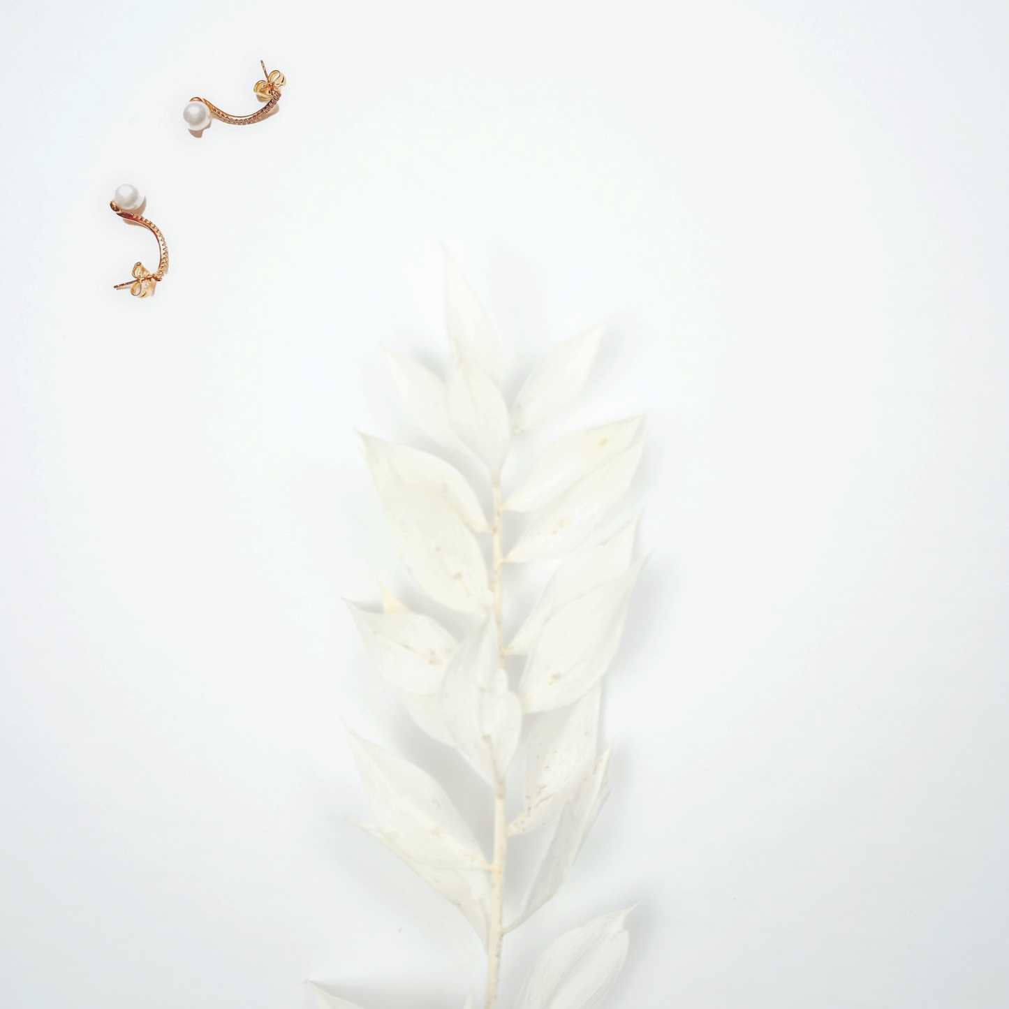 Crooked-top earring featuring a golden plated element and classic pearl, exuding timeless beauty and simple elegance by Hikaru Pearl.