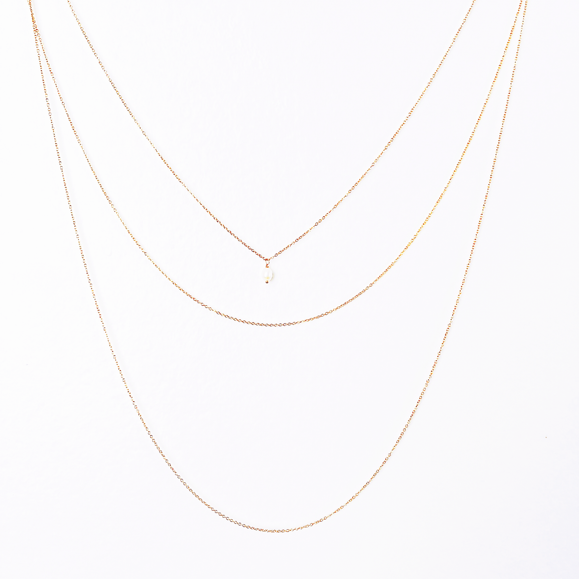 Front and back long necklace featuring three loops with white pearl accents.