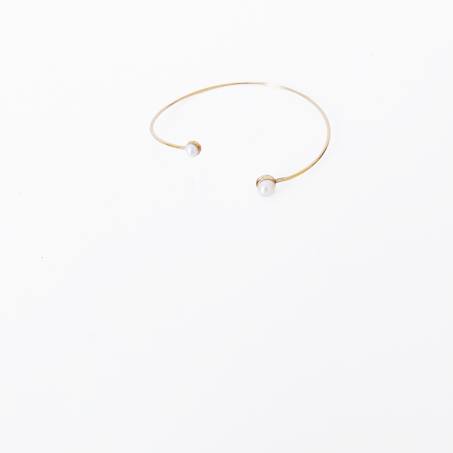 Open gold bracelet adorned with varying sizes of pearls by Hikaru Pearl