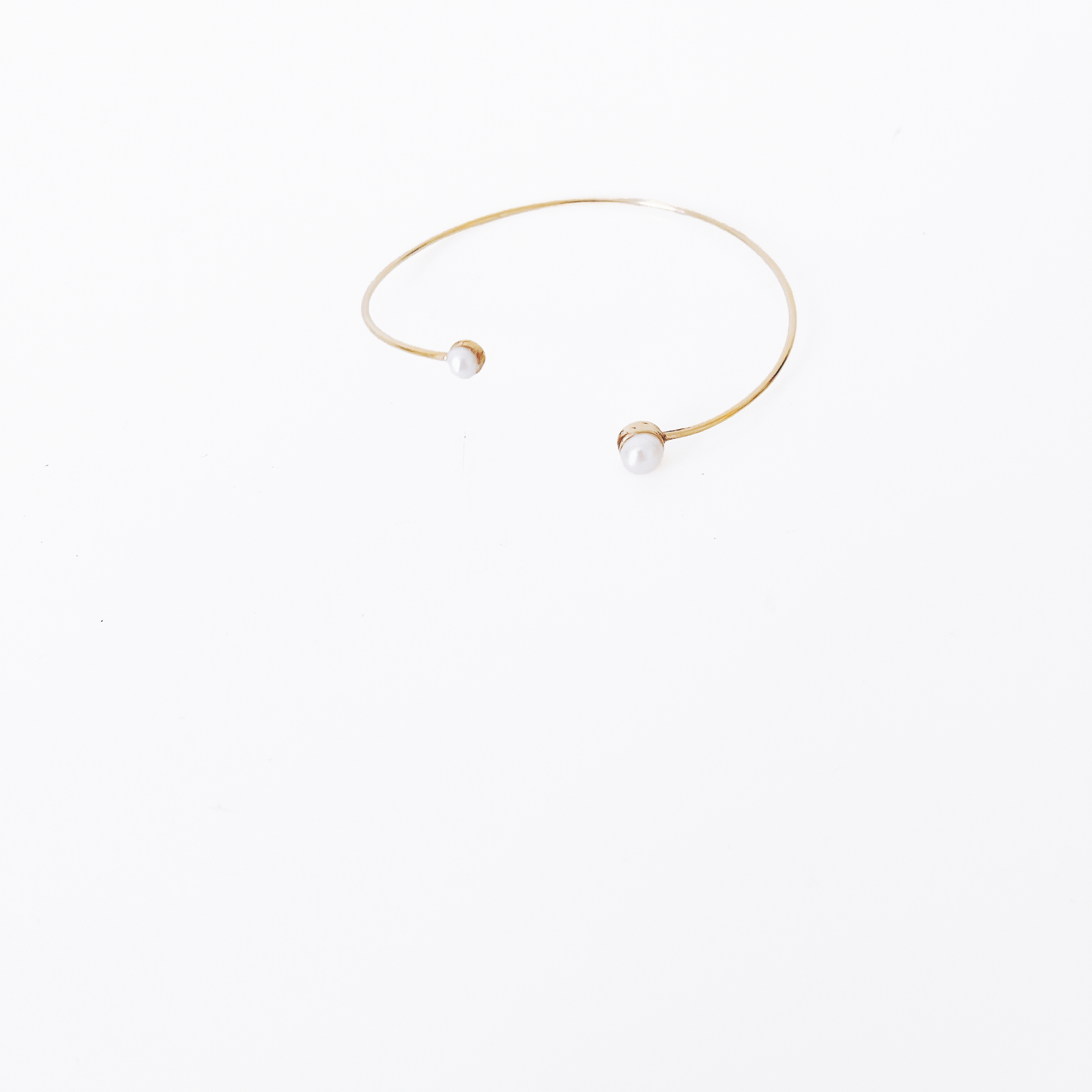 Open gold bracelet adorned with varying sizes of pearls by Hikaru Pearl