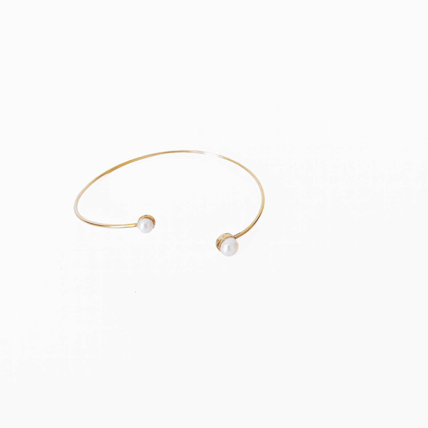 Open gold bracelet adorned with varying sizes of pearls by Hikaru Pearl