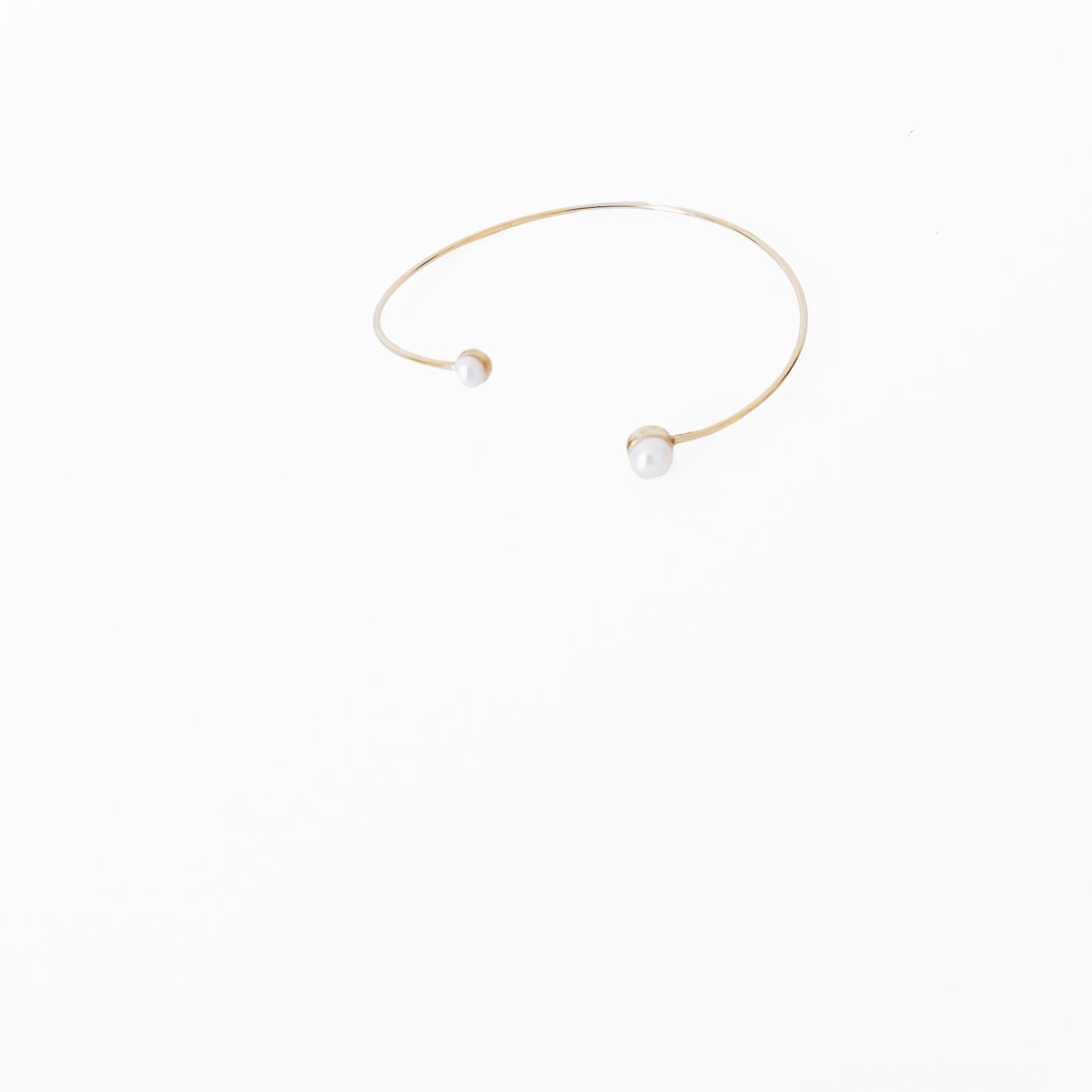 Open gold bracelet adorned with varying sizes of pearls by Hikaru Pearl