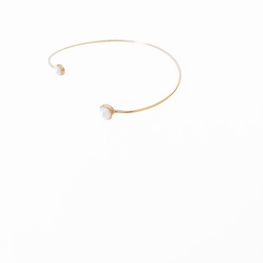 Open gold bracelet adorned with varying sizes of pearls by Hikaru Pearl